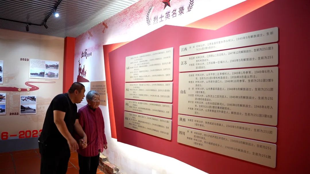 烈士纪念馆登记了解放军庙供奉的27名烈士名录,图为张凯陪奶奶重温烈士名单。杜志鑫摄